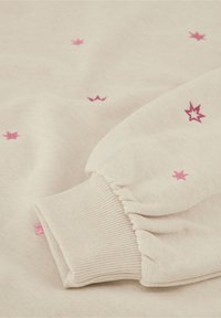 Lichtbeige sweatshirt met roze ster borduursel, ribgebreide manchetten en zachte, textured stof. Het heeft een elastische mouwontwerp.