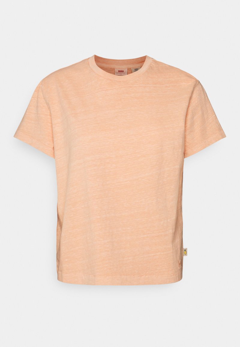 Ljus persikofärgad t-shirt med kort ärm, tillverkad i mjukt, texturerat tyg med rund halsringning, och har en liten etikett på nedre vänstra sidan.