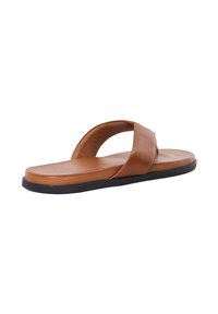 Brown leather flip-flop with a wide, cross-strap design and a contoured footbed. The outsole is black and slightly textured.