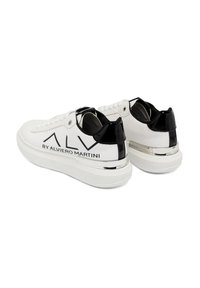 Sneaker bianco con dettagli in pelle verniciata nera e finiture cromate. Caratterizzato da allacciatura frontale e logo audace sul tallone. Suola in gomma.