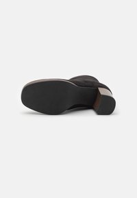 Black suede ankle boot with a rounded toe, wooden block heel, and smooth rubber sole. Soft texture with minimal detailing.