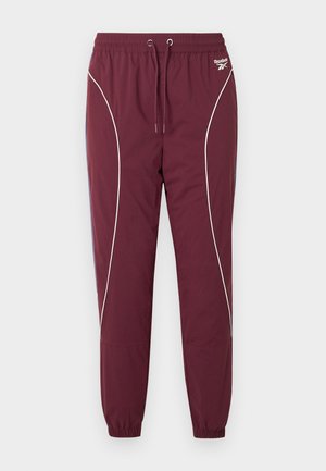 Bordeauxrote Sporthose mit elastischem Bund und Kordelzug. Verfügt über weiße Paspeldetails an den Seiten und elastische Bündchen an den Knöcheln.