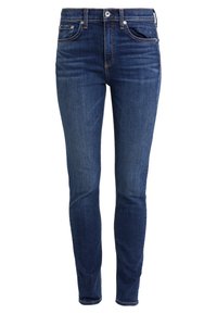 Jeans de corte ajustado hechos de denim azul. Cuentan con bolsillos frontales, una cremallera y costuras en contraste. Textura suave con un desgaste mínimo.