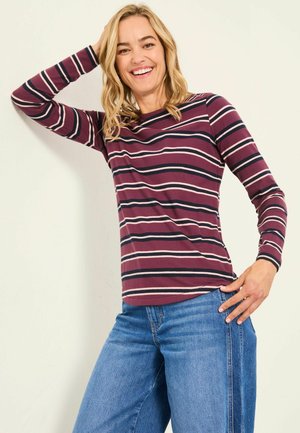 Bordeauxrotes Langarmshirt mit weißen und dunkelblauen Streifen, kombiniert mit blauen weiten Jeans. Glattes Material mit lockerer Passform und Rundhalsausschnitt.