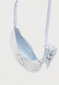 Μικρό τσάντα χιαστί με εξωτερική επιφάνεια σε ανοιχτό μπλε μοτίβο φίδι, κύριο διαμέρισμα με φερμουάρ και προσαρτημένη θήκη για κέρματα με φερμουάρ στο λουρί.