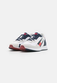 Sneaker che presentano una combinazione di colori bianco, blu navy e rosso; materiali in rete e suede; suola texturizzata; con strisce decorative e lacci.