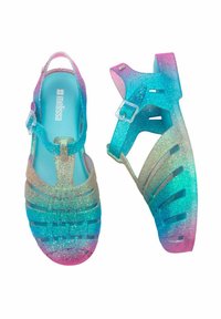 Sandali di gelatina traslucidi con cinturini regolabili alla caviglia, caratterizzati da una gradazione di colore che va dal rosa al blu e una texture glitterata.