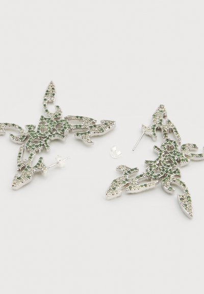 Ασημένια σκουλαρίκια με περίπλοκο, φιλιγκράν σχέδιο και πράσινες πολύτιμες πέτρες, σε σχήμα φύλλων και κληματιδιών. Κλείνουν με πίσω βύσματα.