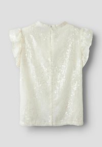 Valge ilma varrukateta särk, millel on tekstureeritud pind ja sädeleva kaunistusega. Omab volangiga õlavarrekaunistusi ja ümarat kaelust.