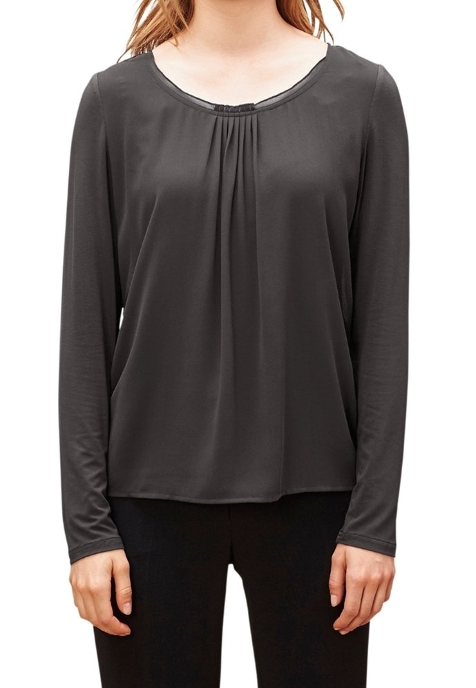 Blouse à manches longues en charbon avec un col rond, une texture douce, un détail froncé au centre, et une coupe décontractée, associée à un pantalon foncé.