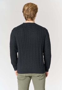 Maglione blu navy a trecce con maniche lunghe, polsini e orlo a coste. Presenta un motivo a rilievo e un classico scollo rotondo.