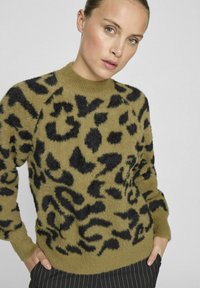 Olivno zeleni pulover s črnimi leopardjimi vzorci, narejen iz mehkega, teksturiranega materiala. Ima dolge rokave in okroglo ovratnik.
