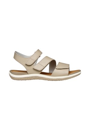 Sandale beige à bout ouvert avec trois bandes Velcro réglables et une semelle en caoutchouc texturée pour plus de confort et de maintien.