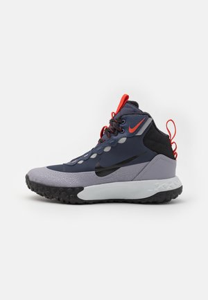 Scarpa da ginnastica alta con colori blu navy, grigio, nero e arancione, suola testurizzata, lacci e logo Nike Swoosh sul lato e sulla linguetta.