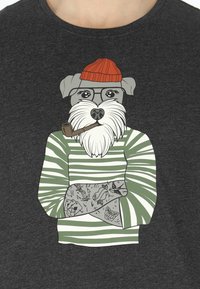 T-shirt grigia con una grafica di un cane con barba, che indossa un berretto rosso e un maglione a righe verdi, con disegni di tatuaggi sulle braccia.