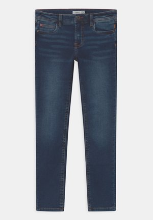 Jean slim bleu foncé avec poches avant et arrière, fermeture par boutons, et détails délavés le long des cuisses et des genoux.