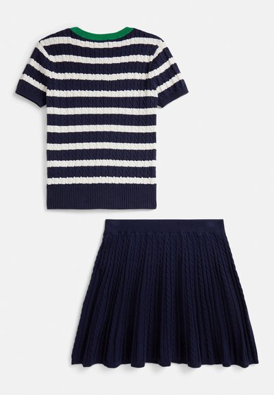 Tmavomodrý pletený top s krátkymi rukávmi s bielymi pruhmi a zeleným lemom na výstrihu, v kombinácii so zodpovedajúcou plisovanou sukňou s textúrovanými detailmi.
