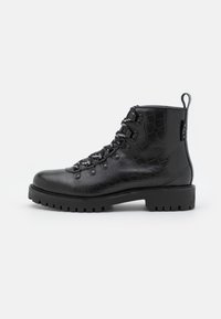 Botines negros con textura de cocodrilo, con punta redonda, herrajes plateados y cordones en blanco y negro, sobre una suela negra robusta.