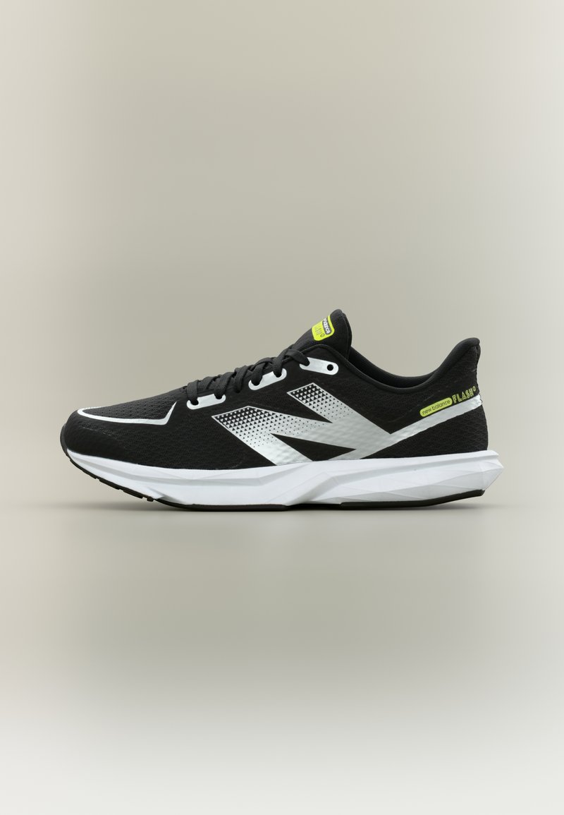 Mustvalge New Balance jooksujalats võrgust pealsega, kollaste logomärkidega ja pehmendusega tallaga, külgprofiilis beige taustal.