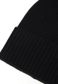Beanie nera realizzata in un morbido knit testurizzato. Presenta un orlo a coste per un maggiore calore e un design pulito e semplice.