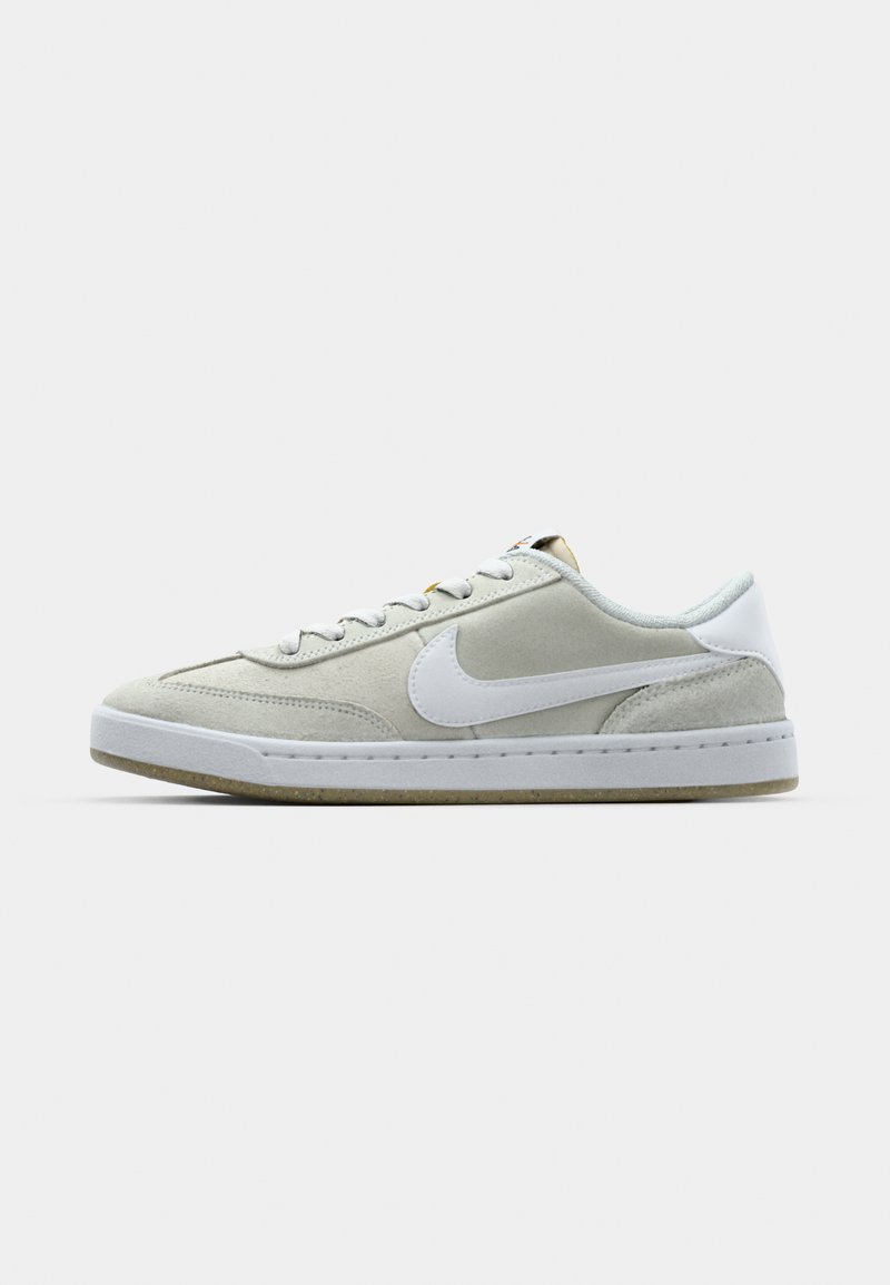 Zapatillas de ante gris con un logo Swoosh de cuero blanco, que presentan cordones blancos, una suela de goma sólida y una lengüeta texturizada.
