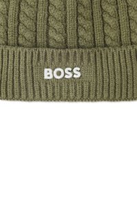 Beanie lavorato a maglia verde oliva con motivo a treccia e bordo a coste. Logo "BOSS" ricamato in bianco sul davanti. Texture morbida.