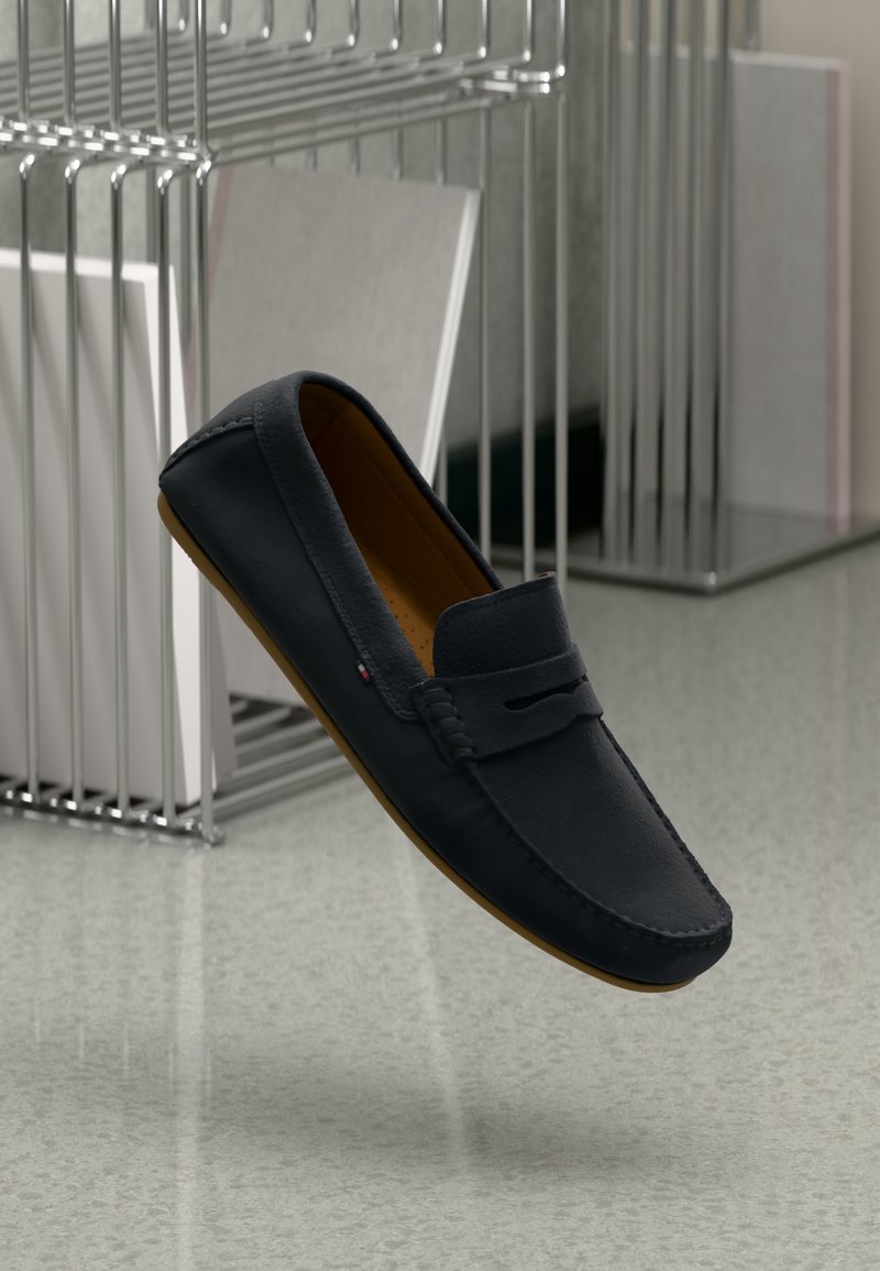 Marine læder loafers med brune gummisåler; rund tå, dekorativ syning og et frontudskæringsdetalje.