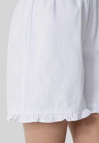 Lichtblauwe shorts van denim, met een gerimpelde zoom en een gladde textuur. Het ontwerp bevat zijnaad en een relaxte pasvorm.