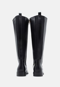 Μαύρες δερμάτινες μπότες μέχρι το γόνατο με υφασμάτινες πλαϊνές πάνελ, λείες επιφάνειες, πίσω φερμουάρ και μικρές στρογγυλές τακούνες.