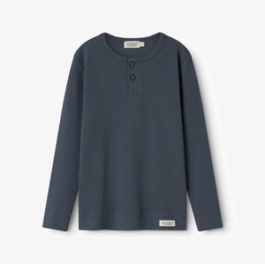 Tamsiai mėlynas ilgomis rankovėmis marškinėliai su raštuotu paviršiumi, apvaliu iškirpimu ir dviem sagomis priekyje. Apatinėje dalyje yra mažas prekės ženklo etiketė.