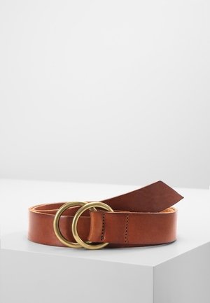 Brown leather belt with double round brass buckle, coiled and placed on a white surface against a light gray background.