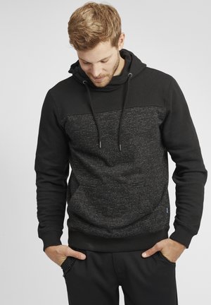 Sudadera negra con una sección superior texturizada que presenta un sutil patrón de líneas horizontales. Cinturillas en el cuello y puños acanalados.