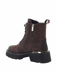 Ciemnobrązowe zamszowe botki za kostkę z zaokrąglonym noskiem, sznurowaniem i zamkiem błyskawicznym, oraz masywną czarną podeszwą z srebrnym akcentem.