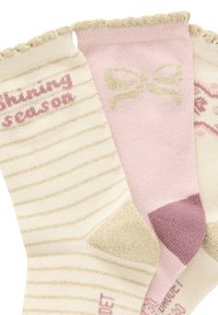 Drei Paar Socken: eines mit goldgestreiftem Creme, eines in einfarbigem Pink mit einer Schleife und eines mit pinken Akzenten und einem Muster in Creme.