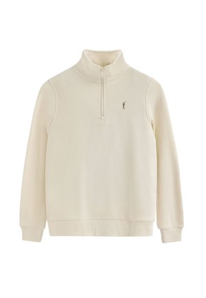 Sudadera cremosa con cremallera hecha de tela suave; presenta un cuello alto, puños de canalé y un pequeño logo marrón en el pecho.