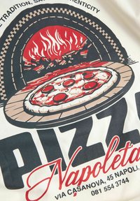 Koszulka z grafiką pizzy w piecu opalanym drewnem, z czerwonymi płomieniami, brązowym spodem pizzy, białym brzegiem i czarnym napisem „Pizza Napoletana”.