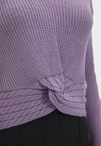 Gebreide lavendelkleurige trui met een gestructureerd lijf en een gedraaide kabelontwerp bij de taille. De mouwen zijn lang en aansluitend.
