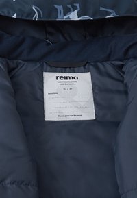 Marine wetterfeste Jacke mit Innenfutter aus weichem Material, Pflegeetikett und Hinweise, um sie weiterzugeben; glatte Textur.