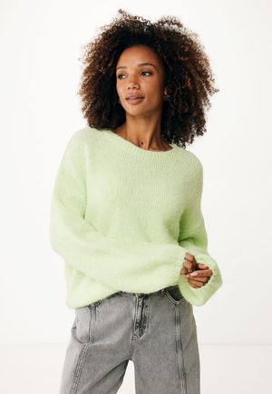 Lichtgroene oversized trui met lange mouwen, zachte textuur en geribbelde halslijn, gecombineerd met hoog-was grijze jeans.