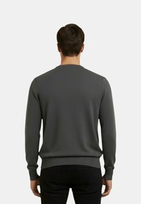 Maglione grigio lavorato a maglia con scollo rotondo, polsini e orlo a coste, dalla texture liscia e design aderente.