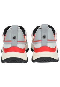 Vue arrière de chaussures de sport avec un dessus gris, des accents rouges, un talon noir et une semelle texturée. Comprend une languette grise et un détail de marque.