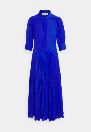 Robe blue en bouton sur le devant avec un col, des manches courtes bouffantes et une jupe plissée. Texture à pois sur l'ensemble du tissu.