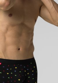 Czarne slipki z kolorowym, pikselowym wzorem postaci z gier, wykonane z miękkiego, elastycznego materiału, z markowym pasem.