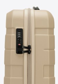 Valigia rigida beige con superficie texturizzata. Dotata di un lucchetto a combinazione, doppie cerniere e un design robusto.