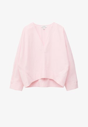 Blouse rose clair à manches longues avec col en V, coupe ample et ourlet arrière plus haut, avec poignets boutonnés et détails subtils des coutures.