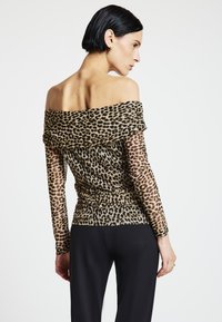 Schulterfreies Oberteil mit Leopardenmuster, aus transparentem Stoff, mit langen Ärmeln und gerafften Details an der Taille.
