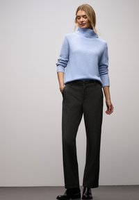 Jasnoniebieski sweter z golfem wykonany z miękkiej dzianiny, zestawiony z szerokimi spodniami w ciemnoszarym kolorze i czarnymi botkami za kostkę.