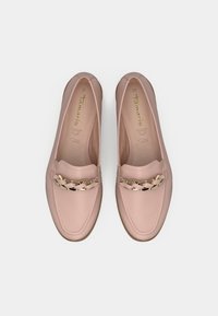 Μια ζευγ άρι ανοιχτό ροζ δερμάτινα loafers με χρυσή αλυσίδα στο μπροστινό μέρος, που φαίνονται από πάνω σε λευκό φόντο.