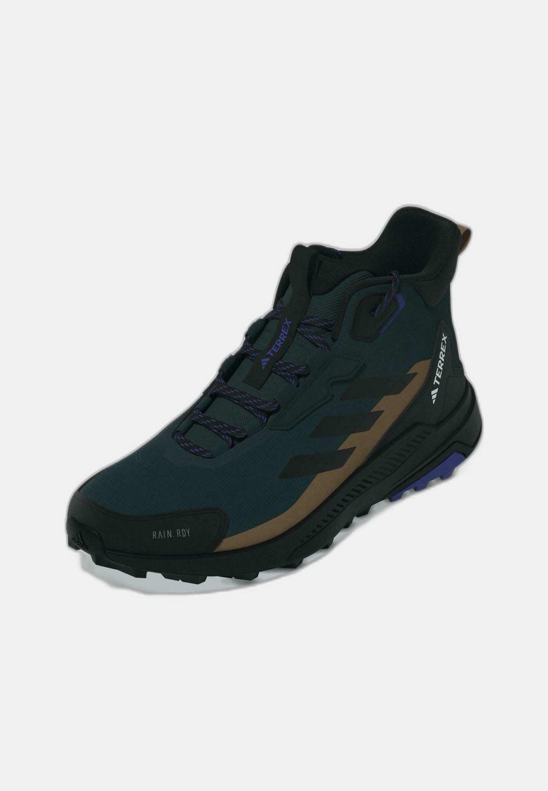 Scarpa da trekking nera e verde scuro con supporto alto alla caviglia, tessuto texture, dettagli viola e logo marrone a contrasto.