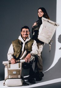 Világos bézs és olívazöld hátizsákok, tartós anyagból készültek. Állítható pántokkal, felgombolható tervezéssel és elülső hálós zsebbel rendelkeznek.